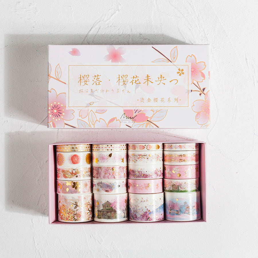 Set of decorative washi tapes in a box with floral designs on a light background