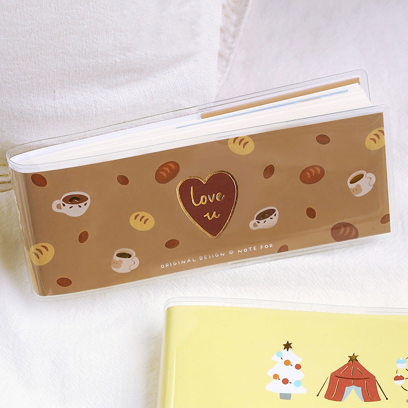 Notebook with a heart and 'love u' design on a brown background, with another notebook featuring Christmas illustrations.