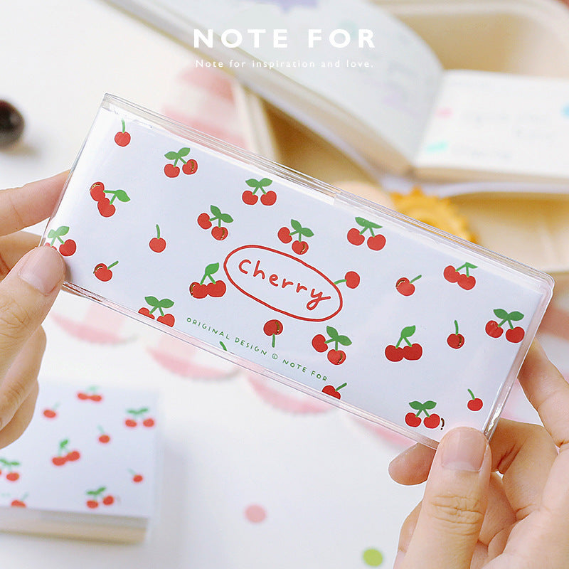 Transparent notebook cover with cherry pattern held by a hand
