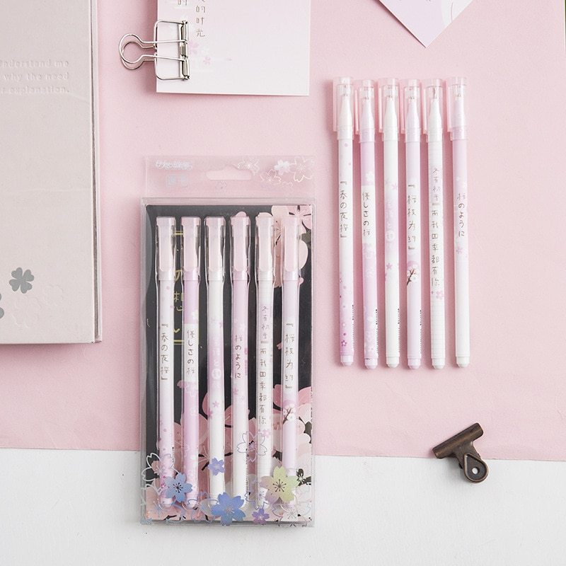 Set of pens with floral design packaging on a pink background