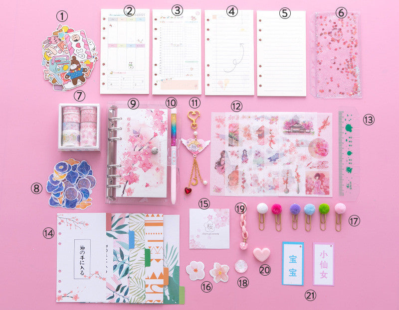 Pink aesthetic stationery flat lay featuring notebooks, planner pages, washi tape, decorative stickers, colorful pom-pom clips, and kawaii accessories arranged on a pink background