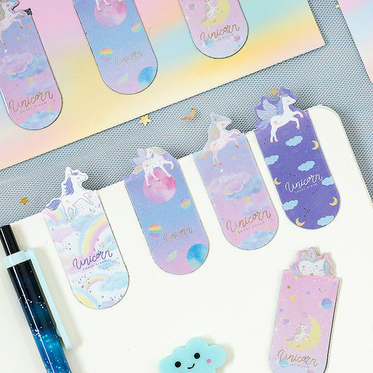 Pastel-colored unicorn-themed assorted bookmarks on a gray surface with a pen.
