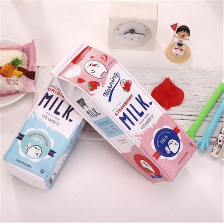 Two milk carton Pencil Cases, one strawberry and one vanilla, on a white surface with stationery items.