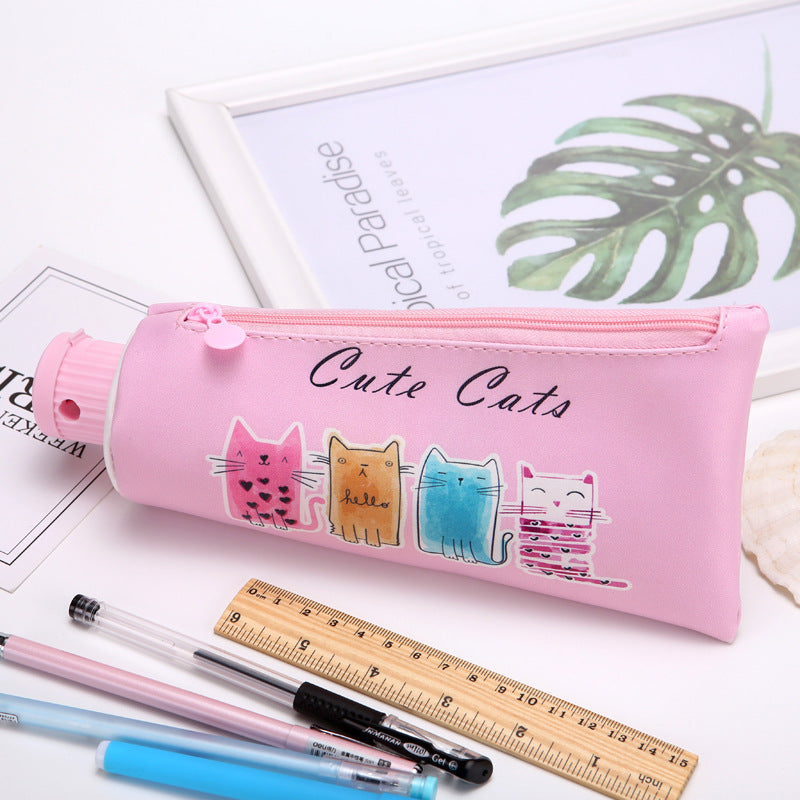Pink Toothpaste pencil case with cat designs on a white surface with stationery items.