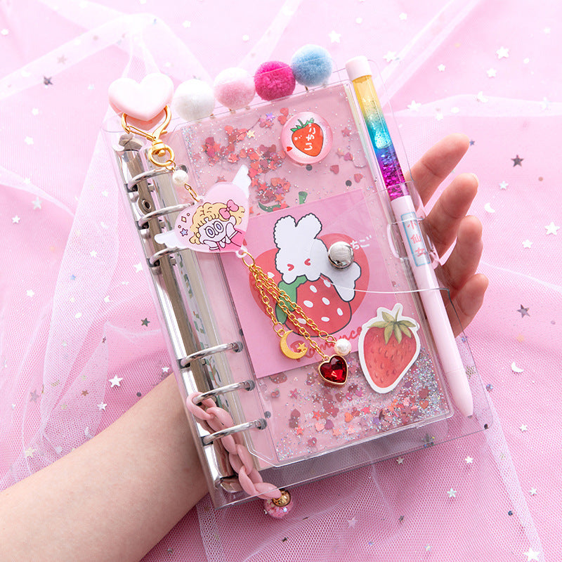 Pink planner with decorative elements and a pen on a pink background