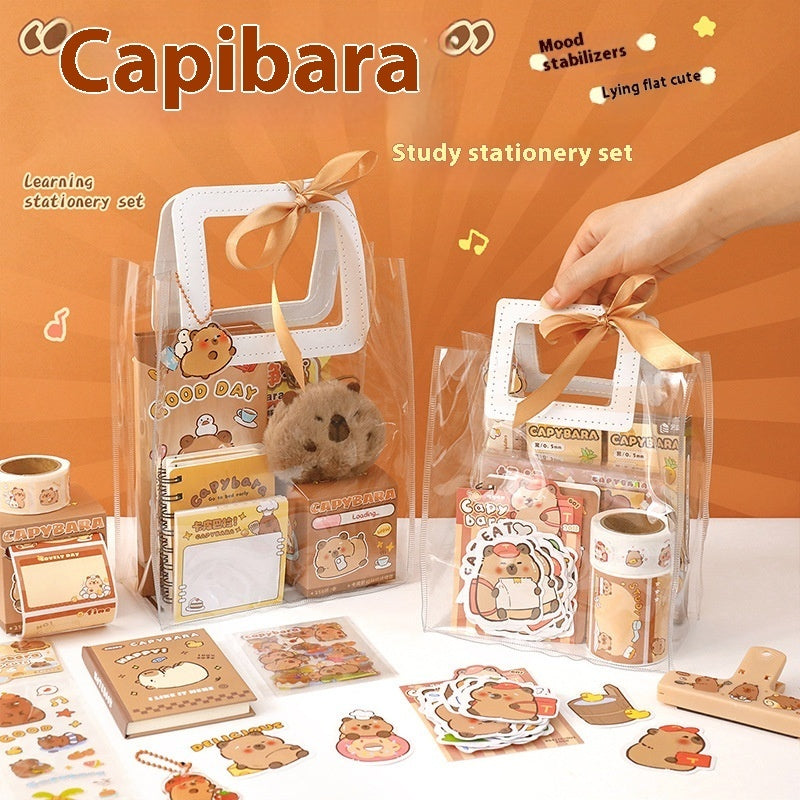 Capybara-themed study stationery set with a hand holding a clear bag containing stationery items on an orange background.