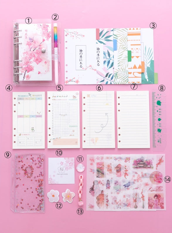 Pink aesthetic stationery flat lay featuring notebooks, planner pages, washi tape, decorative stickers, colorful pom-pom clips, and kawaii accessories arranged on a pink background