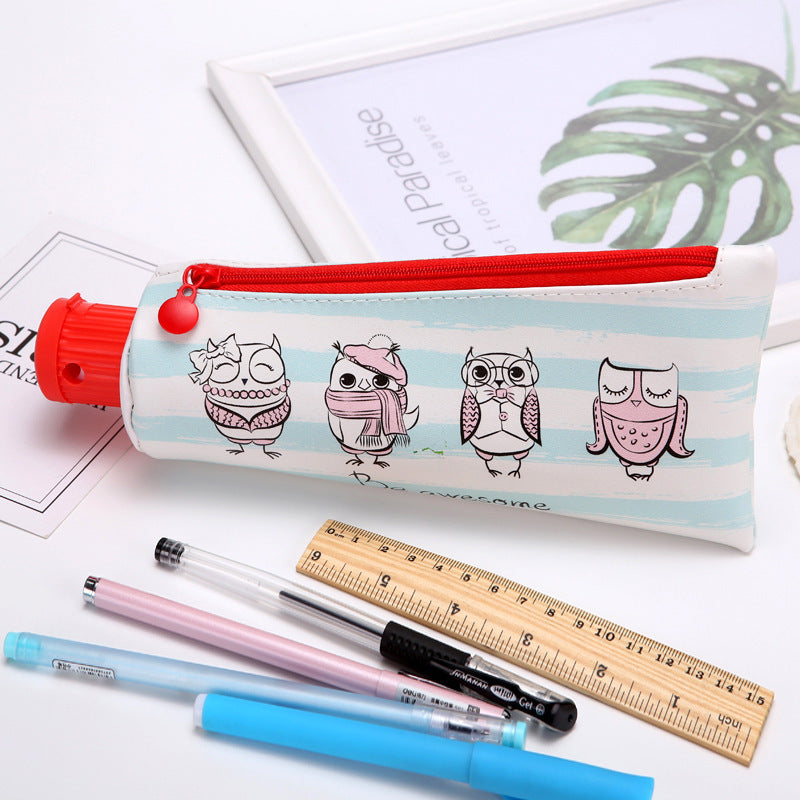 Toothpaste Pencil case with owl design, pens, and ruler on a white background